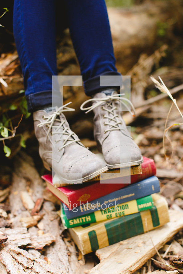 feet on a stack of books outdoors 