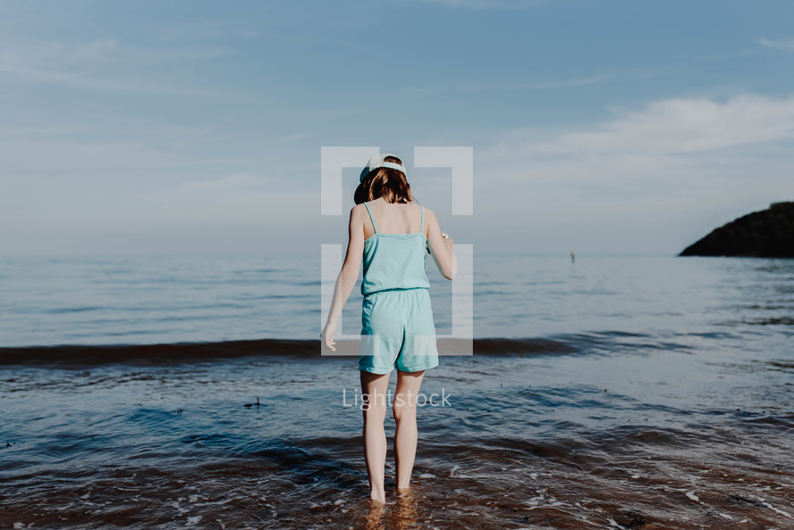 a girl standing in the ocean 