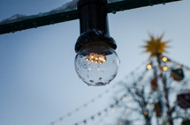 An individual light in a string of outdoor lights.