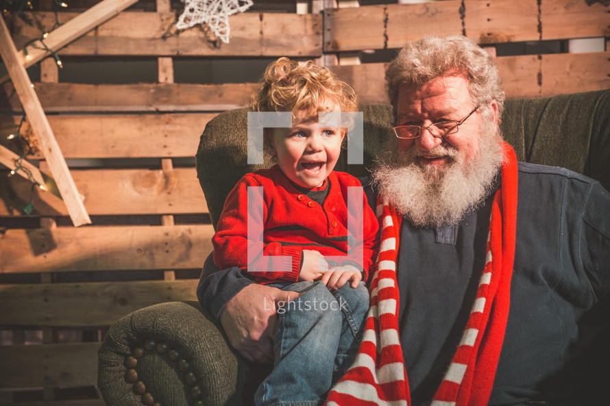 happy toddler sitting on grandfather's lap