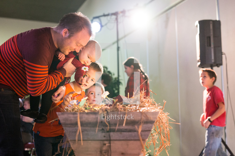 children placing flowers in a manger 