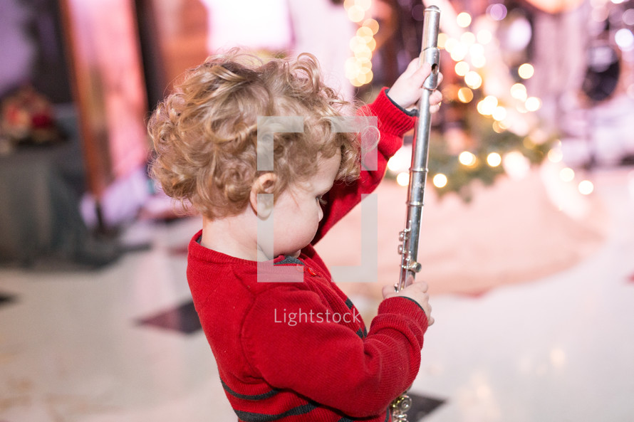 a toddler boy holding a flute 