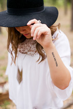 portrait of a woman in a black hat and tattoo 