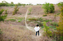 woman running down a hill on a path 