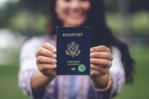 a woman holding a passport outdoors 