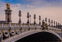 gold and marble bridge with ornate street lamps 