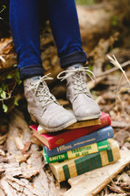 feet on a stack of books outdoors 