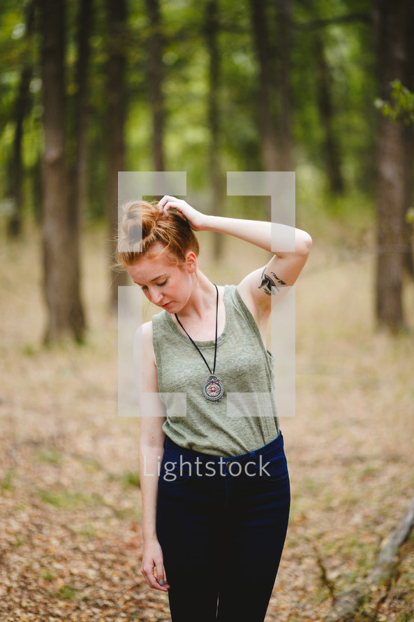 woman standing outdoors scratching her head 