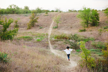 woman walking on a path on a hill 