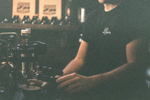 A barista makes a coffee with his hands