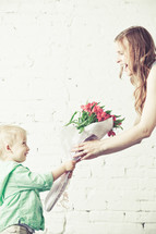 boy handing his mother a bouquet of flowers