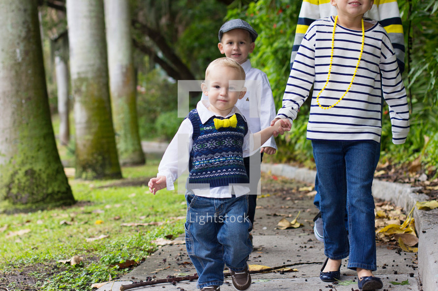 Four children walking along a sidewalk.
