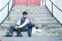father and daughter sitting on church steps 