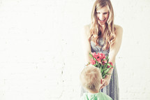 Son giving bouquet of flowers to his mother.