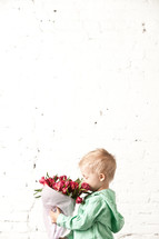 little boy holding a bouquet of flowers