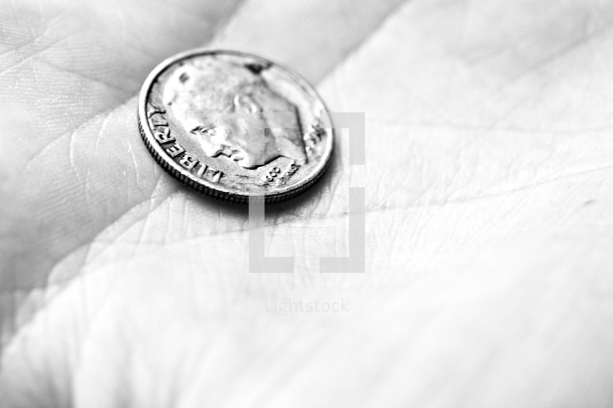 A dime rests in the palm of a hand