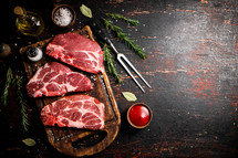 Raw pork steak on a stone board. On a black background. High quality photo