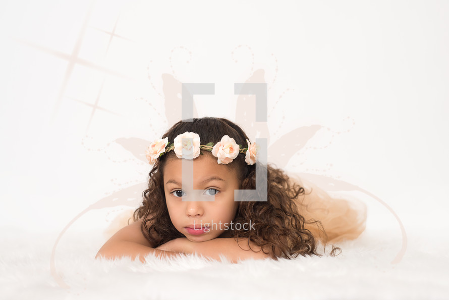 A young girl wearing a wreath of flowers on her head.