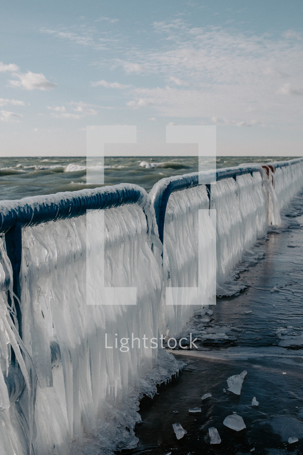 Ice covered railing on beach pier on Lake Michigan