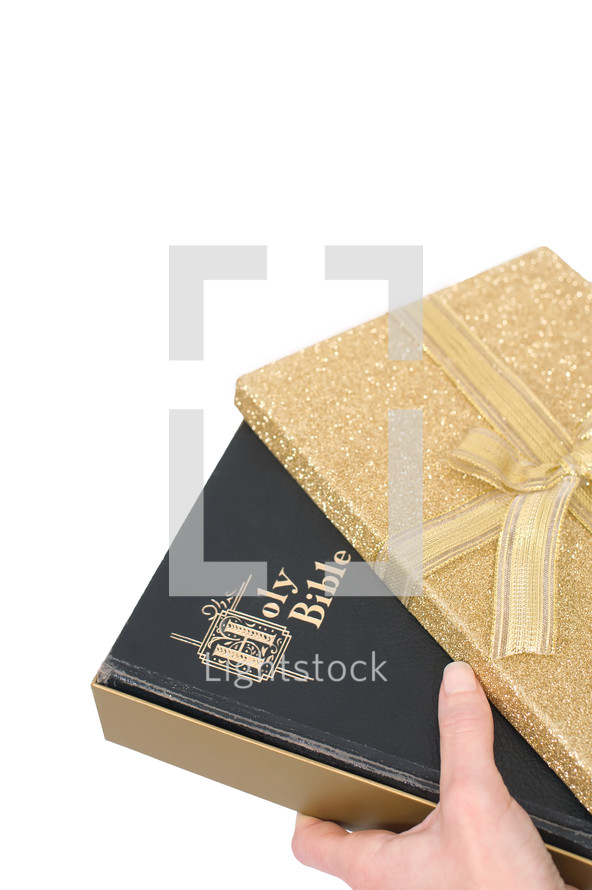 holding a Bible and a wrapped gift 