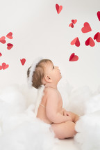 infant in angel wings and red hearts 