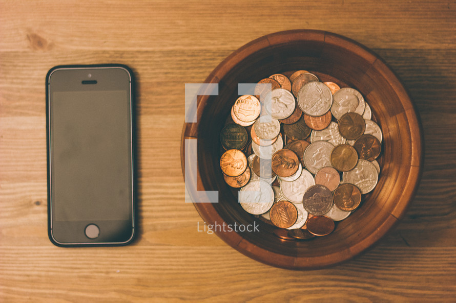 bowl of coins and an iPhone 