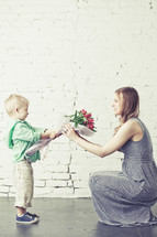 boy handing his mother a bouquet of flowers
