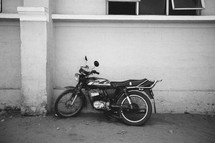 motorcycle leaning against a wall 