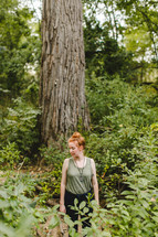 woman standing alone in a forest 