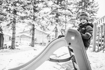 boy playing with a toy truck in the snow 