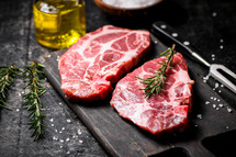 Raw pork steak on a stone board. On a black background. High quality photo