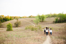 friends walking up a path on a hill 