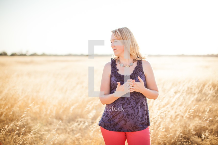 a woman standing in a field of wheat 