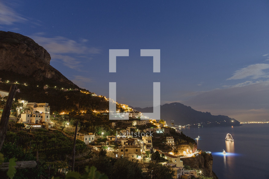 homes along a mountainous coastline in Italy at night 