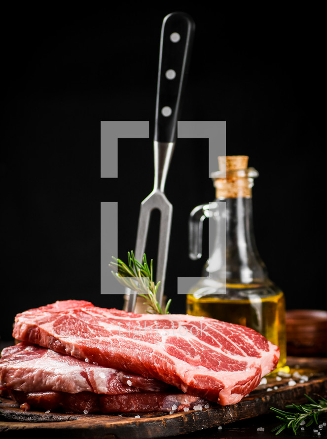 Raw pork steak on a stone board. On a black background. High quality photo