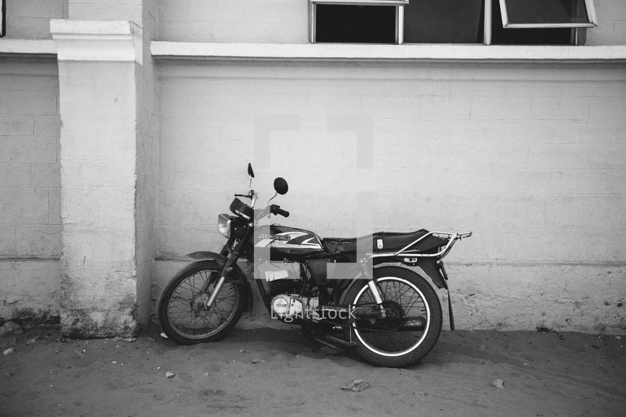 motorcycle leaning against a wall 