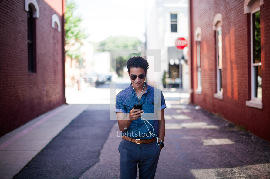 man standing in an alley listening to an iPod 