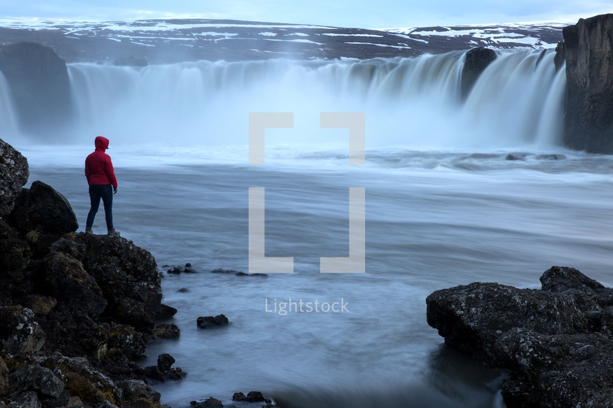 a person watching a waterfall in Iceland 