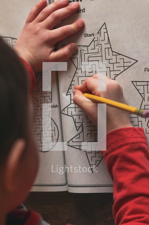 child completing a maze on paper 