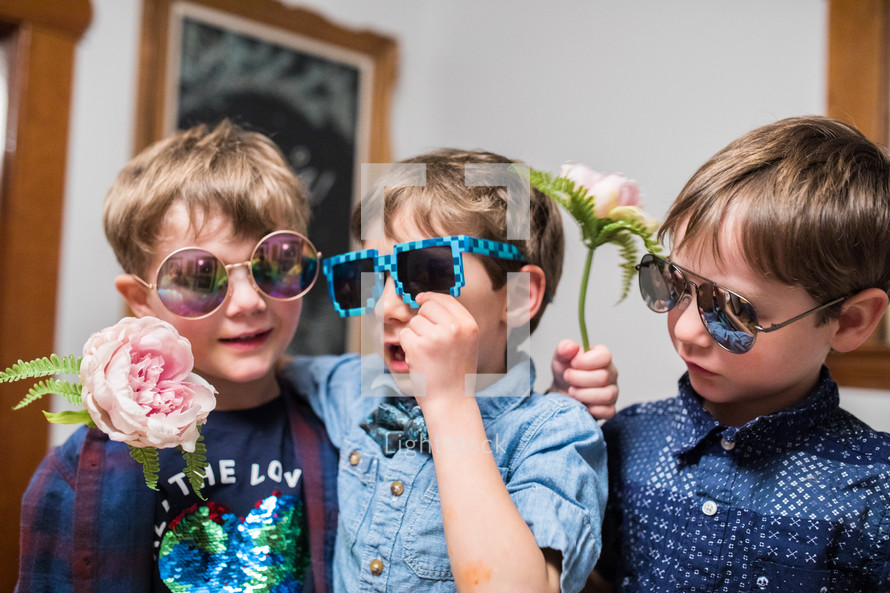 kids in sunglasses holding flowers 