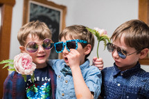 kids in sunglasses holding flowers 