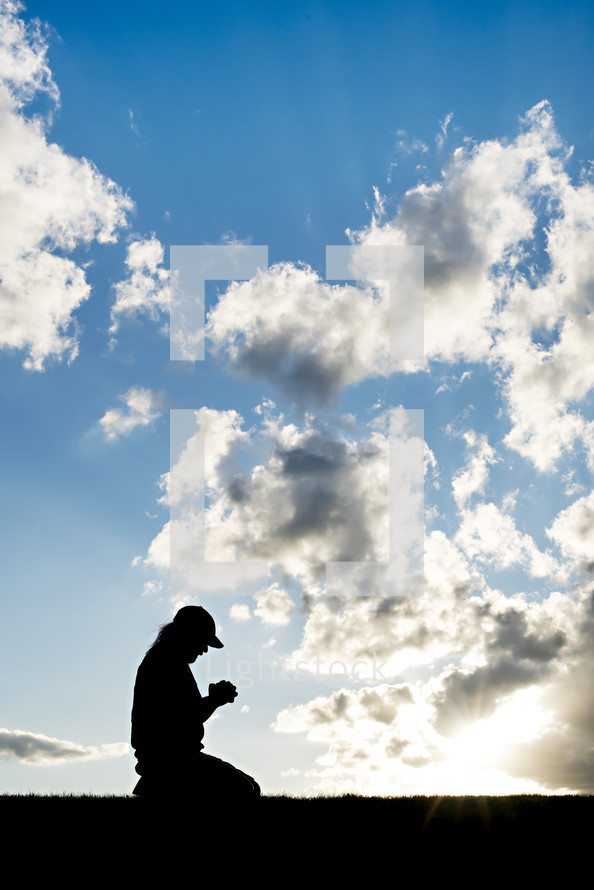 silhouette kneeling in prayer 