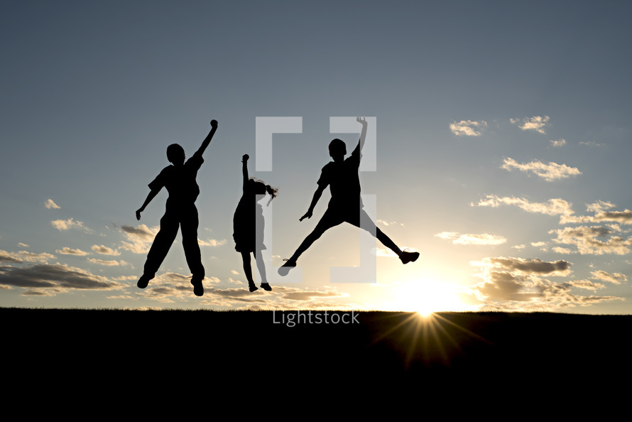 silhouette of children leaping 