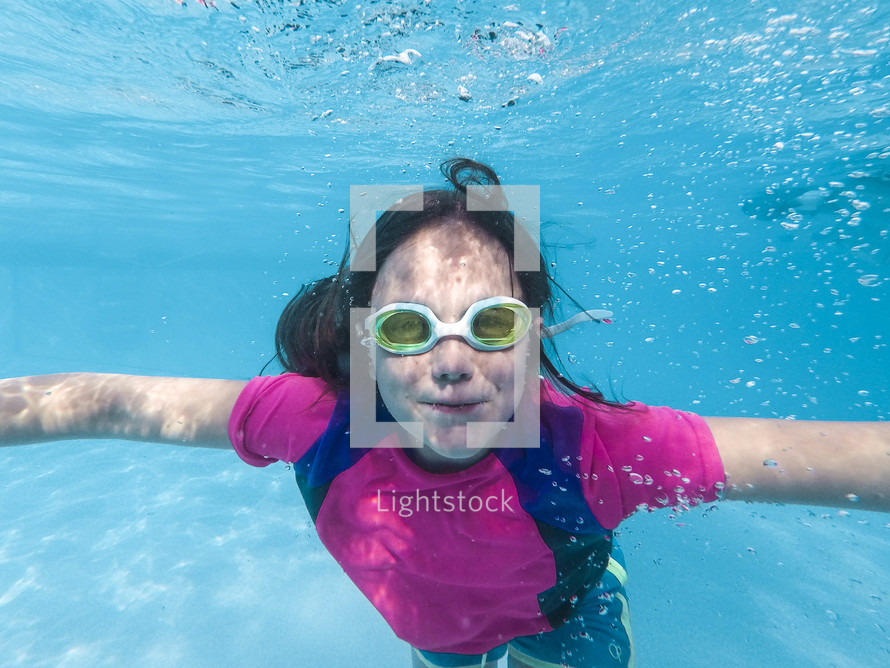 a girl swimming under water 
