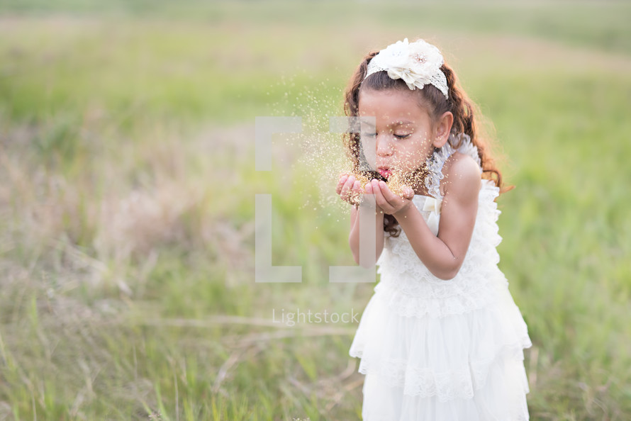 girl child blowing glitter 