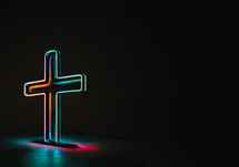 Neon cross on a black background with text space