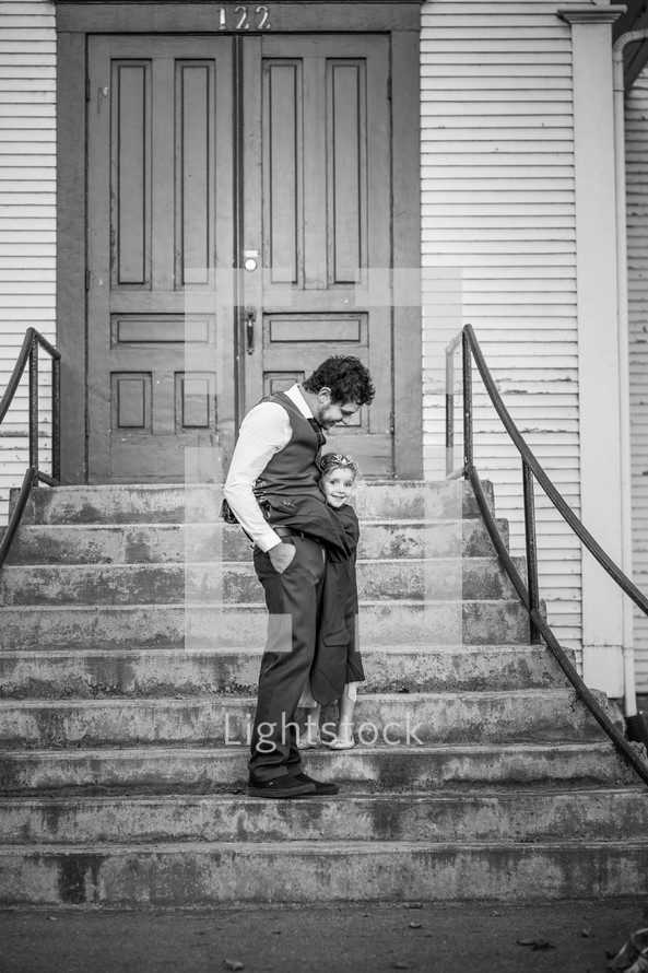 father and daughter hugging on church steps 