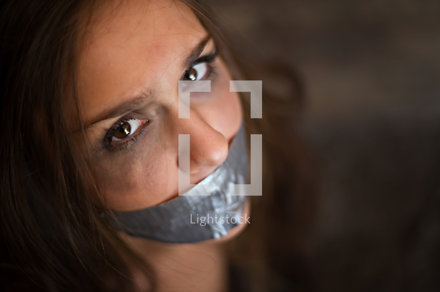 young woman with duct tape over her mouth 