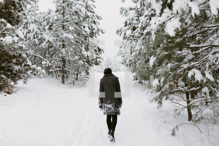 a woman walking through the snow 