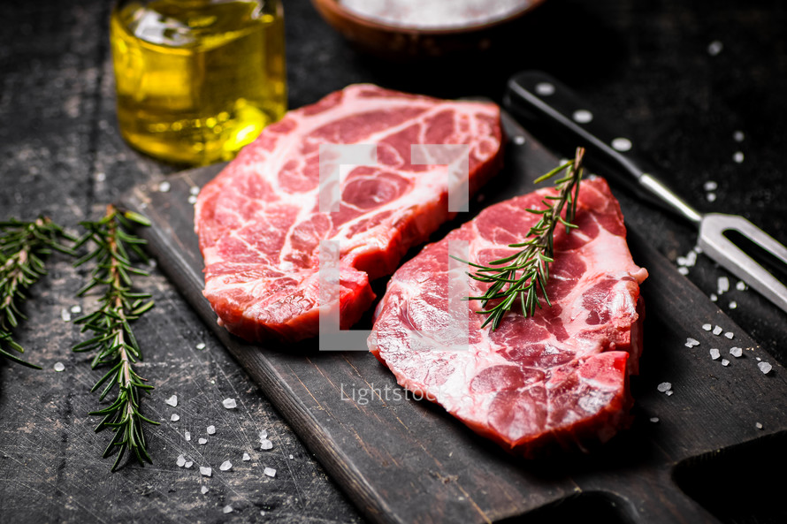 Raw pork steak on a stone board. On a black background. High quality photo